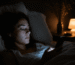 Lumière bleue et sommeil : femme exposée à l'écran de son téléphone le soir