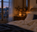 Chambre au crépuscule avec réveil ancien et bougie allumée, pour préparer le changement d'heure et le sommeil