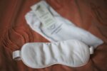 Masque de nuit en bambou biologique blanc écru de Jo Browne, posé à plat avec sa pochette