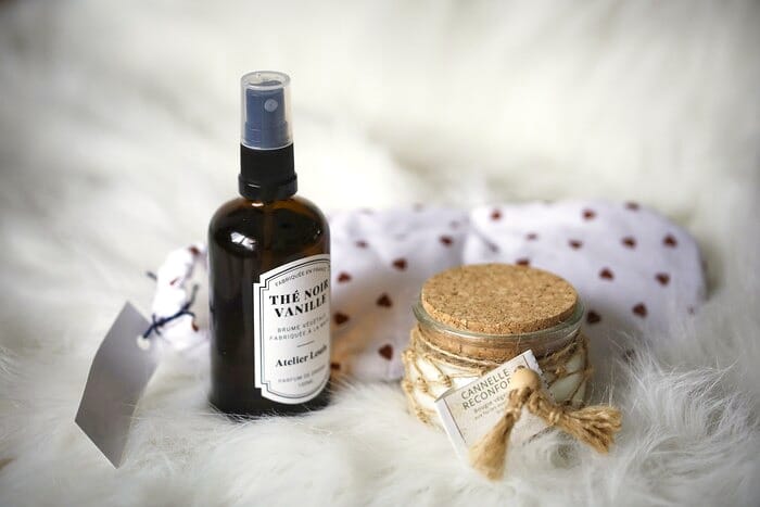 Brume d’ambiance Thé noir & Vanille d’Atelier Louis et bougie Cannelle Réconfortante devant le masque chauffant à motif cœurs